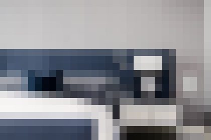 Blurred modern kitchen with dark blue cabinets and a white countertop island, creating a sleek, minimalist look