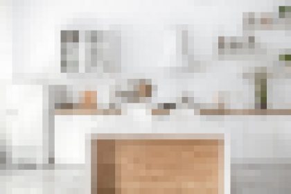 Bright white modern kitchen with an island featuring a wood-front panel and clean countertops trampling minimal decor